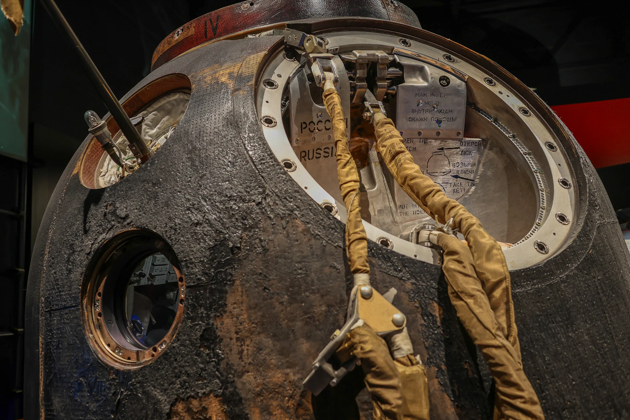 Original Soyuz TMA-03M descent capsule with a scorched exterior and an open hatch displayed at Space Expo