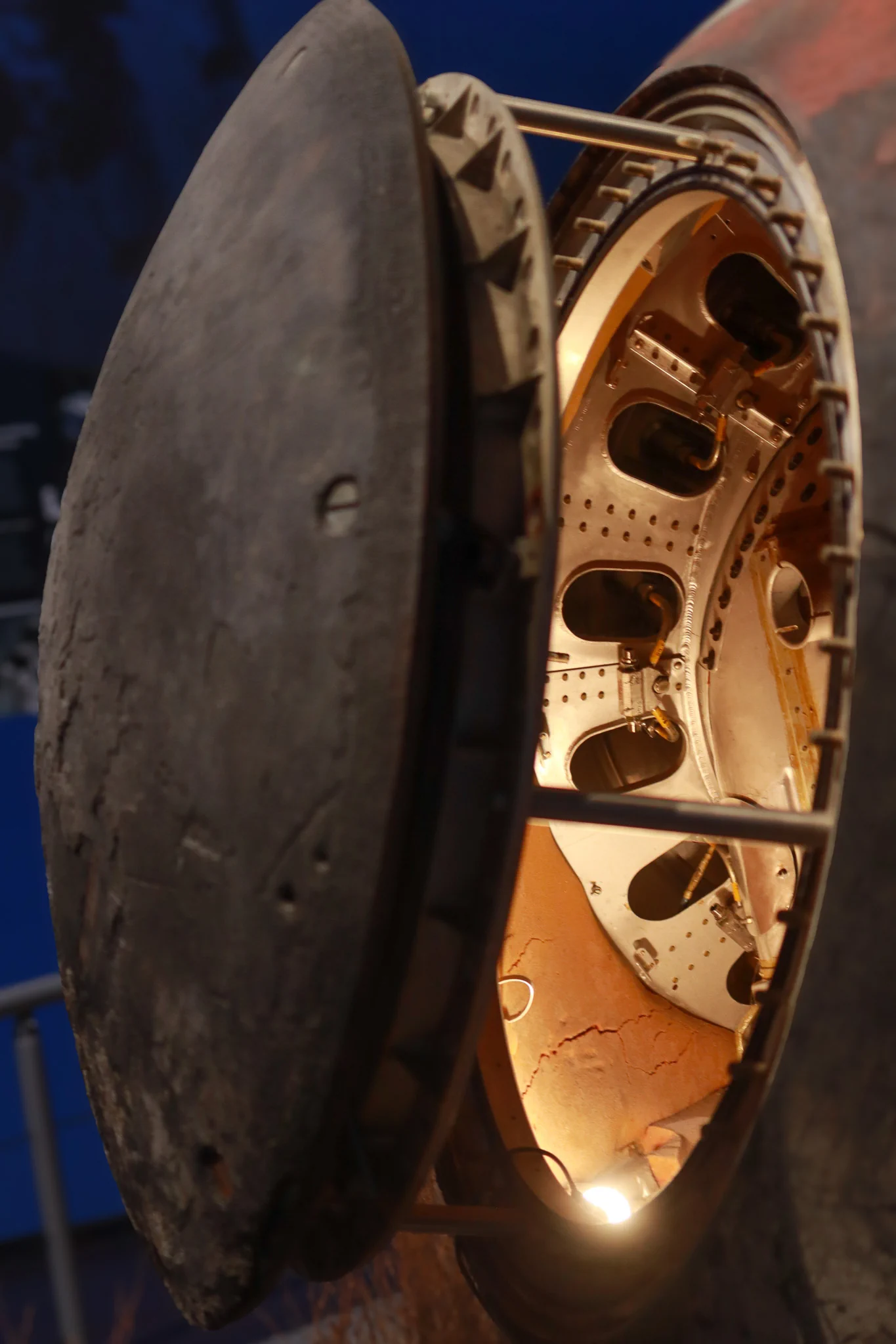 Open circular hatch of the Soviet Resurs F1-14F43 satellite return capsule revealing illuminated internal equipment